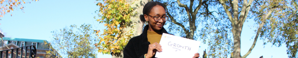 Student in the Walks holding poster saying 'growth'
