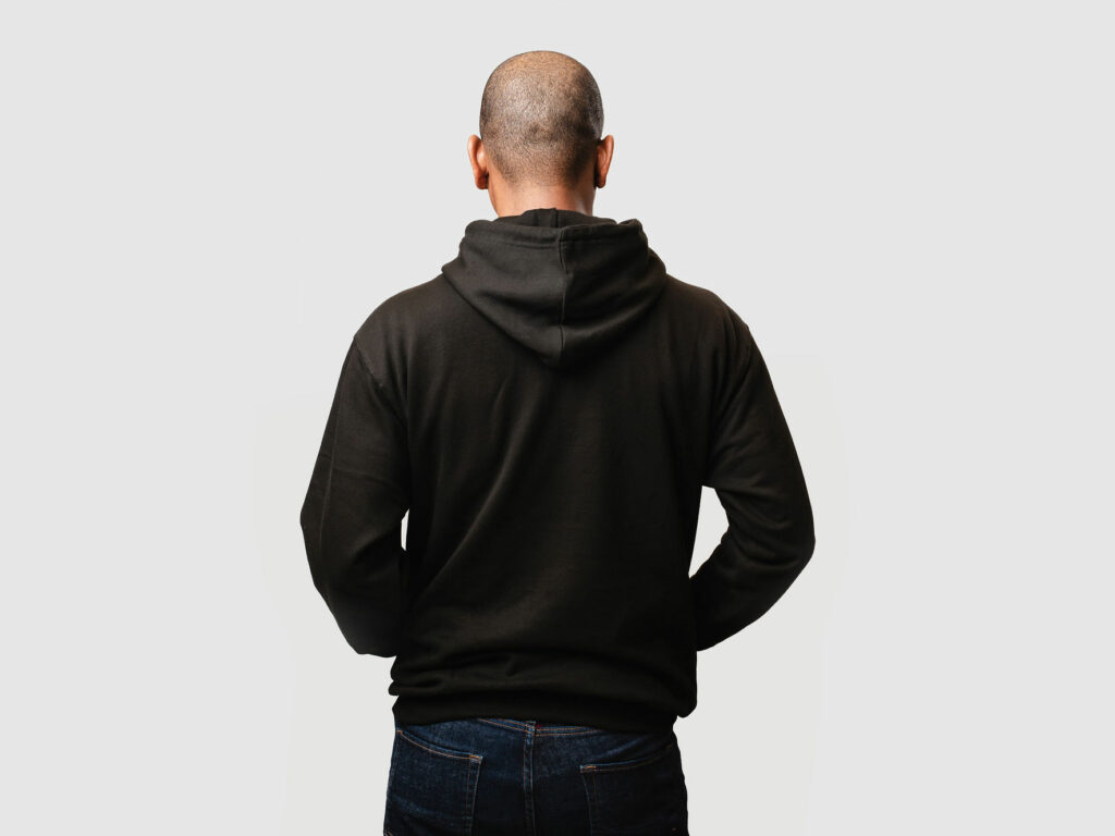 Male model wearing black hoodie - back view