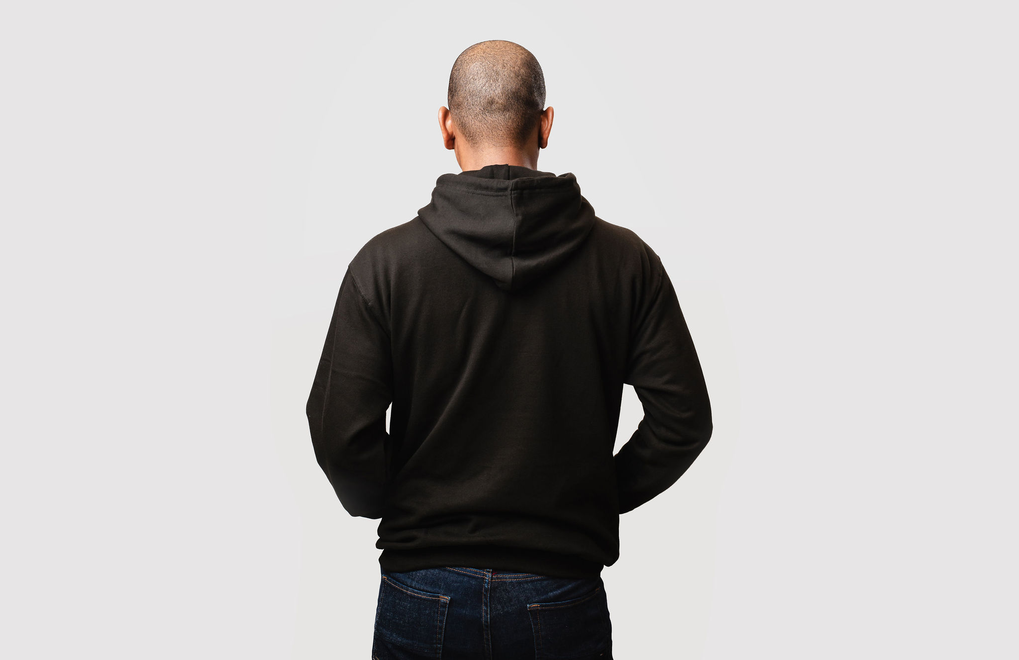 Male model wearing black hoodie - back view