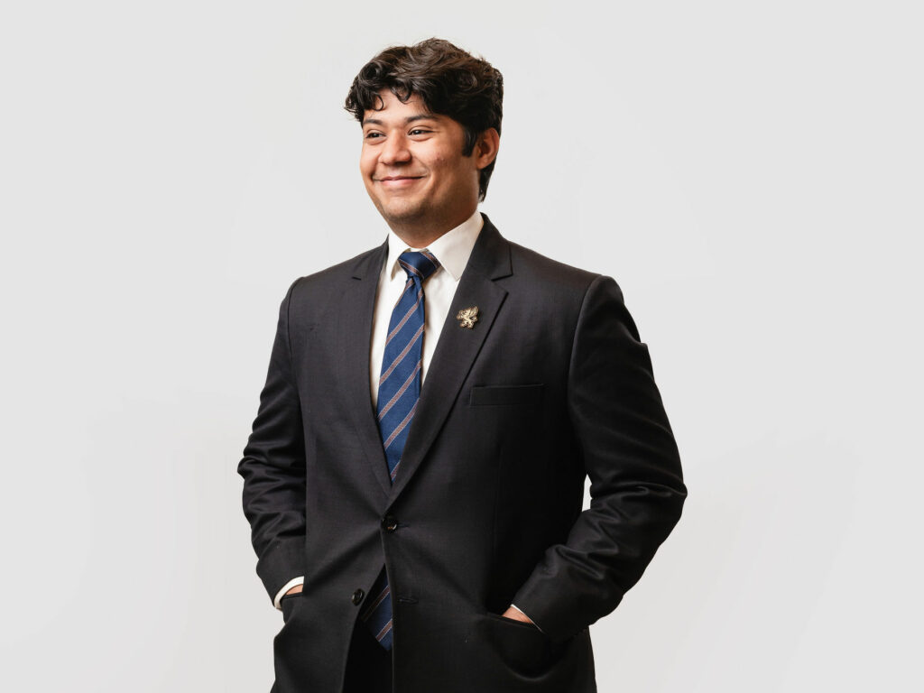 Model wearing suit and enamel lapel pin
