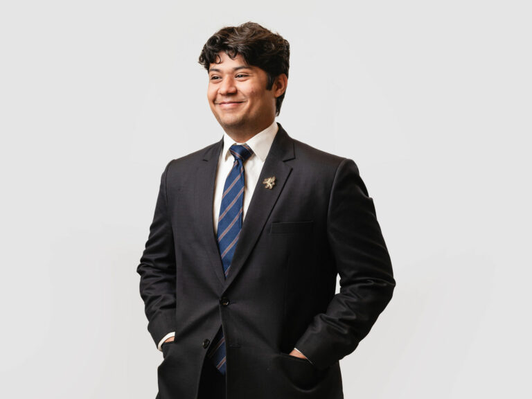Model wearing suit and enamel lapel pin