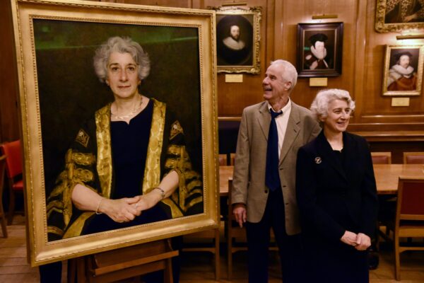 The Right Hon. Lady Rose of Colmworth DBE stands beside her partner during the unveiling of her portrait at Gray’s Inn. The framed portrait, depicting Lady Rose in formal robes with a gold-trimmed gown