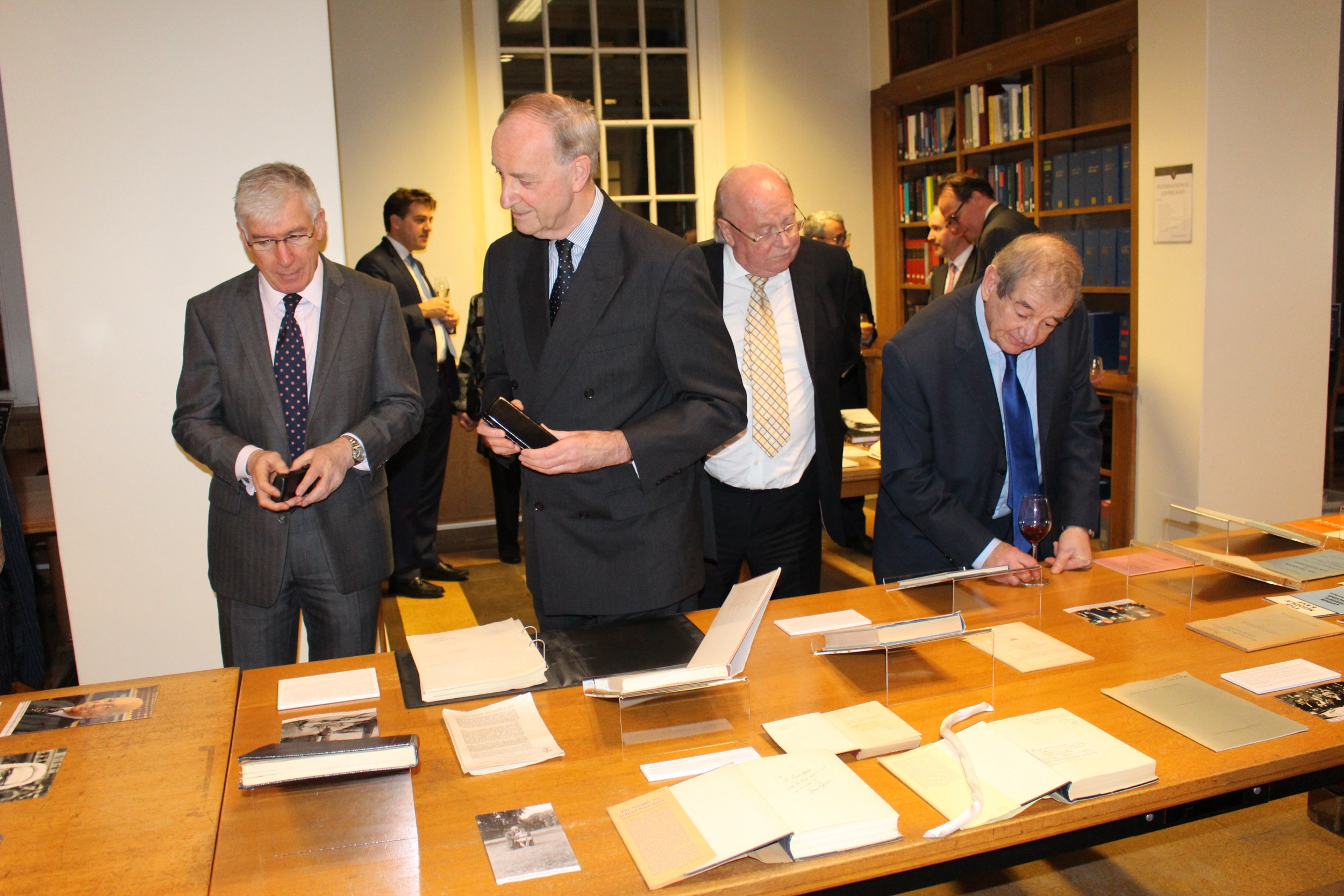 The Treasurer of Gray's Inn Master David Foskett with Under Treasurer Tony Harking and guests viewing the Lauterpacht exhibition at Gray's Inn Library